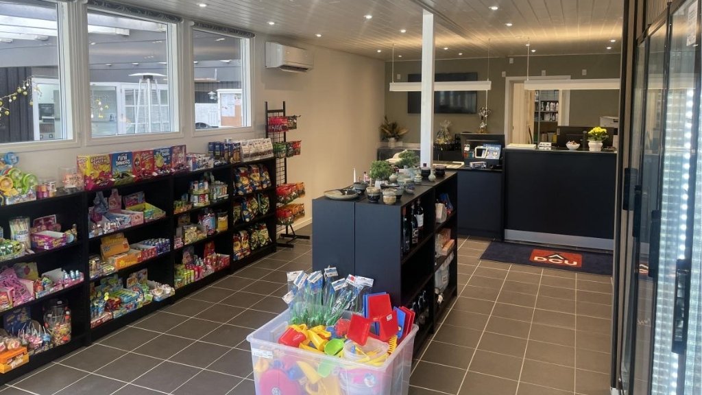 Reception and shop at Kulhuse Camping with coolers and shelves with supplies.