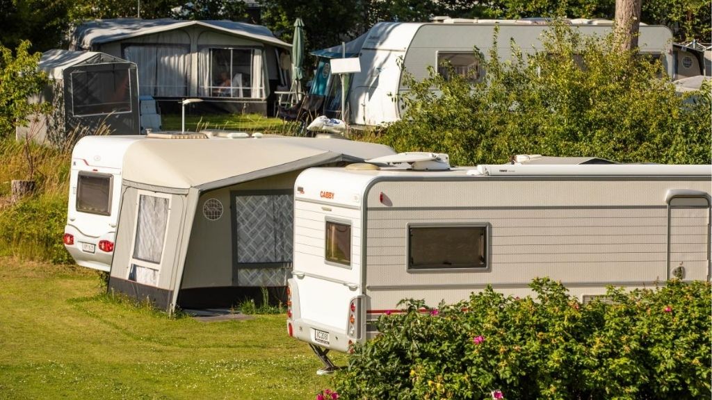 Caravans with awnings in green surroundings at Kulhuse Camping.