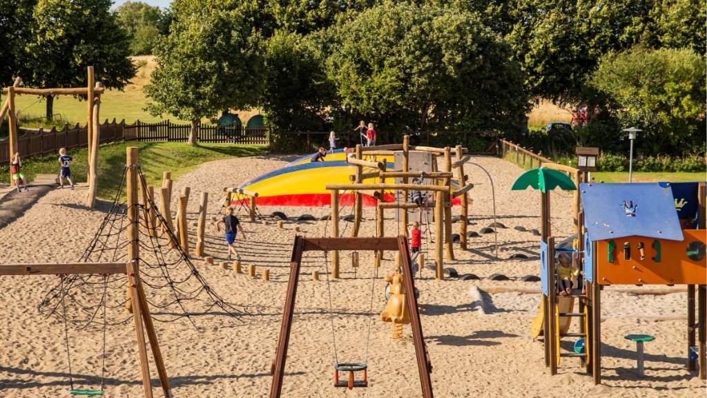 Large playground at Kulhuse Camping with bouncy pillow and climbing structures.