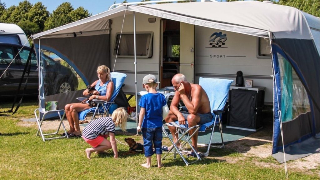 Family in front of caravan at Kulhuse Camping with children and dog.