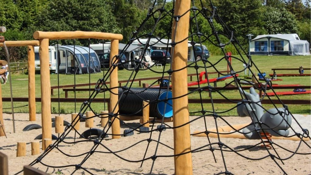 Playground with climbing net and play equipment at Kulhuse Camping.