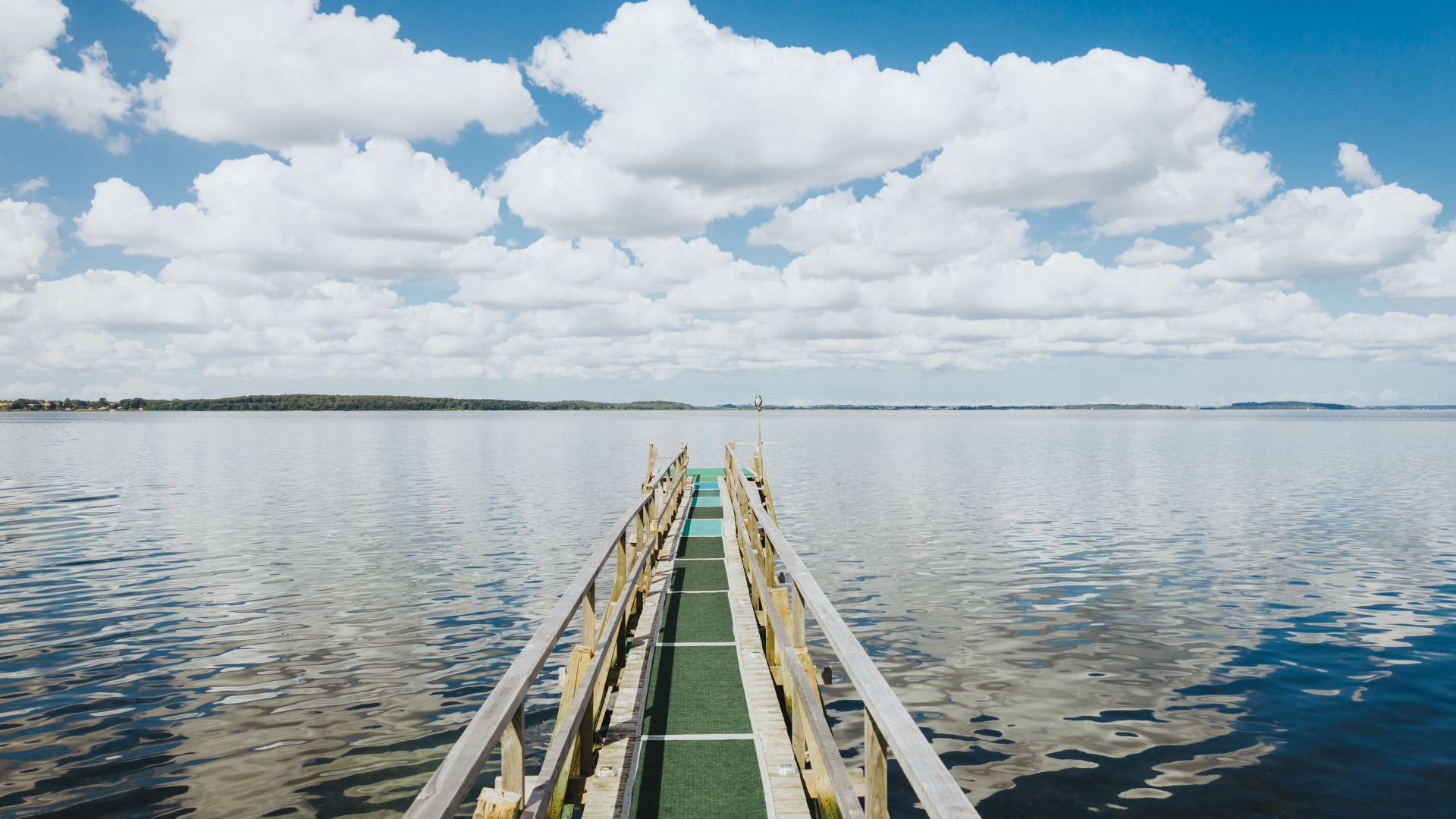 Bathing jetty at Solbakken Camping with view over the fjord and a cloudy sky.