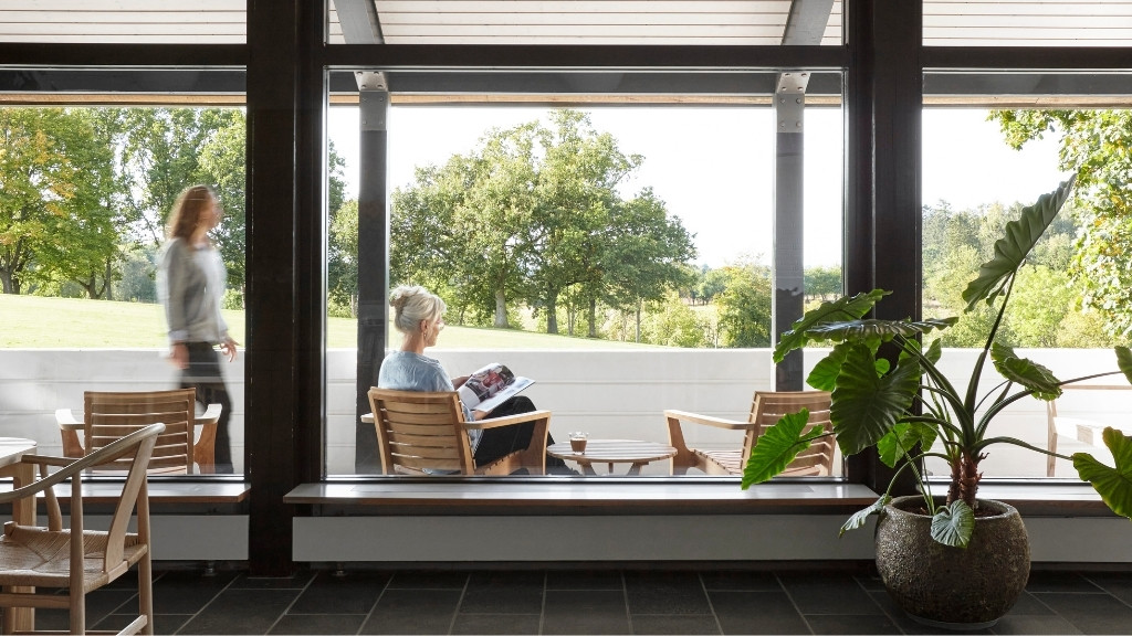 Loungeområde på Metalskolen med siddepladser og udsigt til natur.