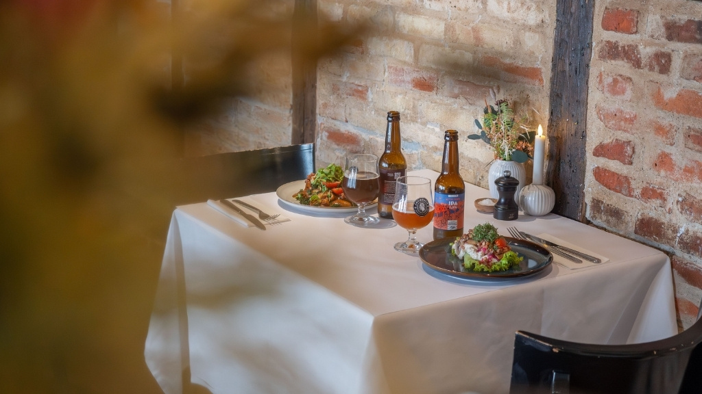 Opdækket bord med mad og øl hos Restaurant Bryggergården til møder og konferencer.