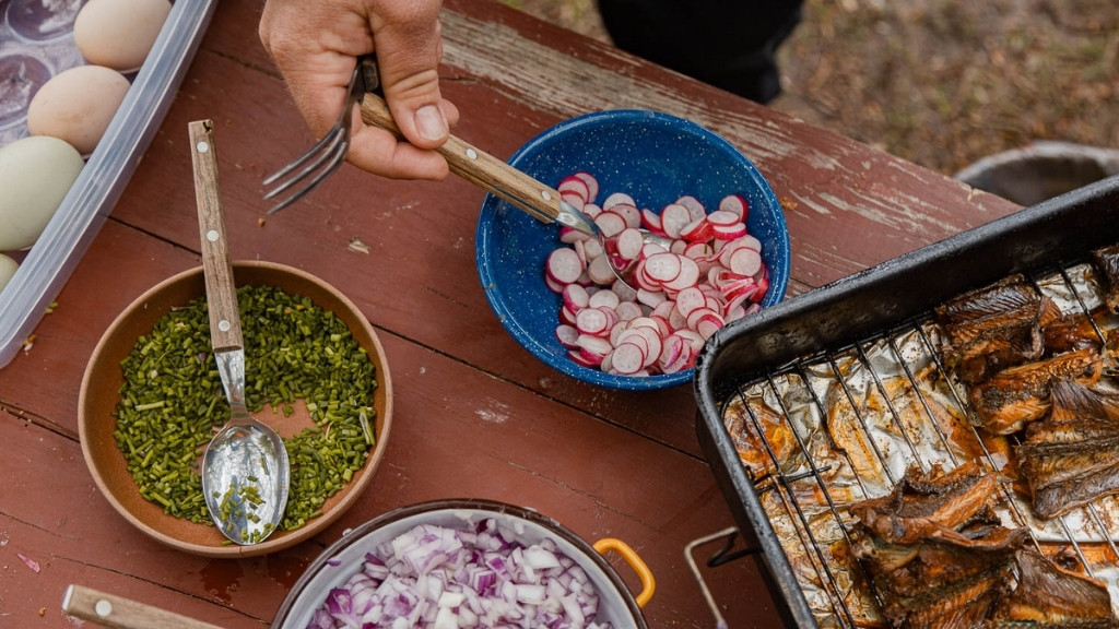 Tilberedning af vild mad med fisk, urter og grøntsager ved Bjælkehytten.