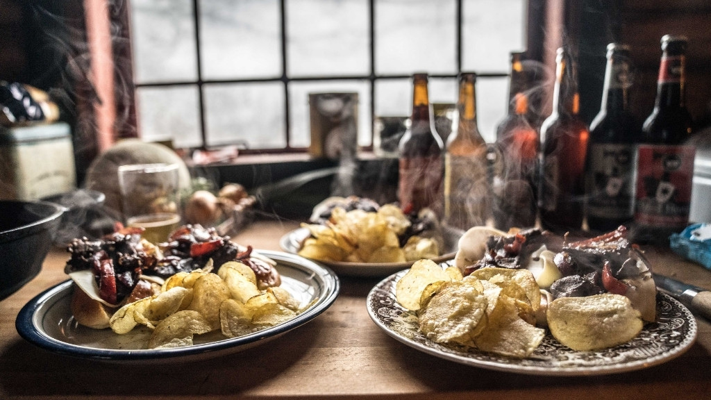 Rustik servering af vild mad i Bjælkehytten med chips, kød og øl.