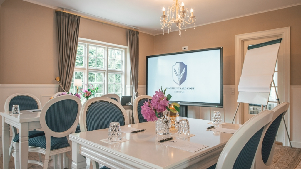 Meeting room at Sonnerupgaard Gods with screen, flip chart and classic interior.