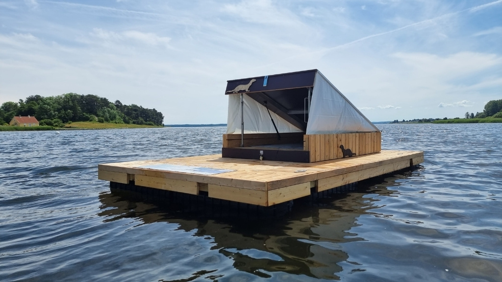 Flydende shelter ved Møllekrogen placeret på vandet med udsigt over fjorden.