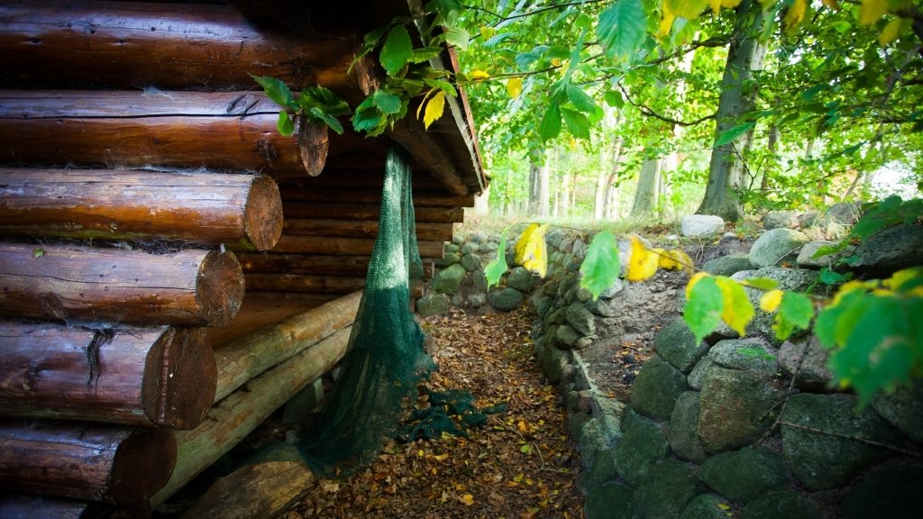 Detailansicht eines Shelters und Steinmauern auf dem Wikingerlagerplatz.