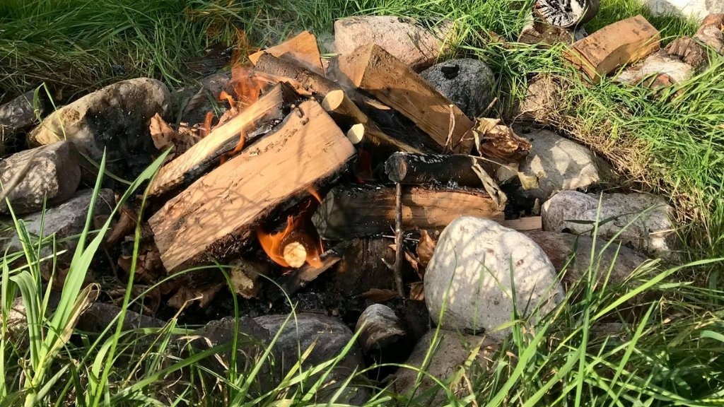 Bålplads ved Løvebakkehus shelterplads med brænde og stenring.