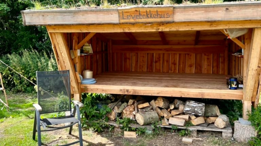 Shelter ved Løvebakkehus med soveplads og opholdsområde foran.