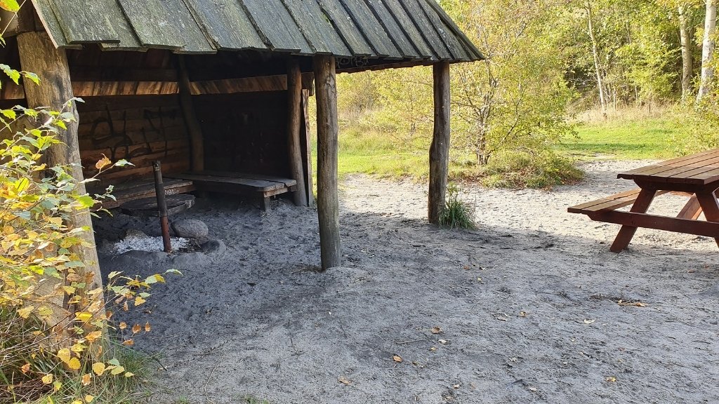Shelter Njord im Sillebro Ådal mit Feuerstelle und überdachtem Aufenthaltsbereich.