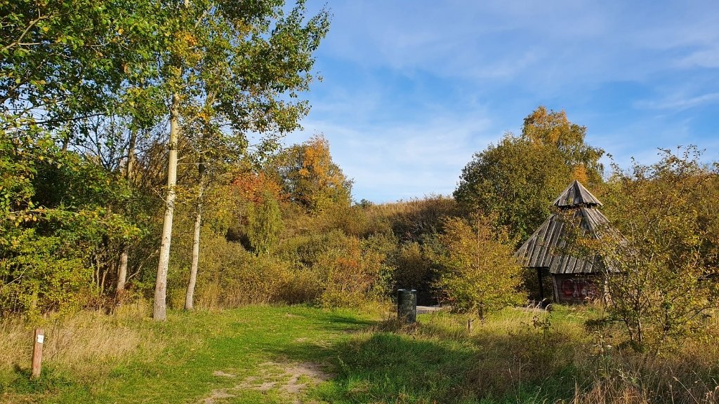 Shelter Njord im Sillebro Ådal umgeben von Wald und offener Landschaft.