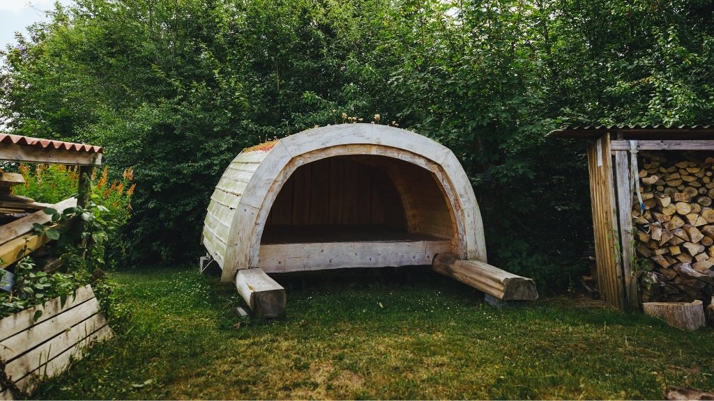 Unterstand auf dem Solbakken Naturistcamping mit Wald und grüner Umgebung.