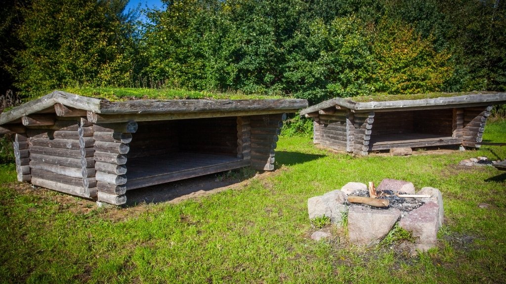 Shelters at Søholm with shared fire pit and open grassy area.