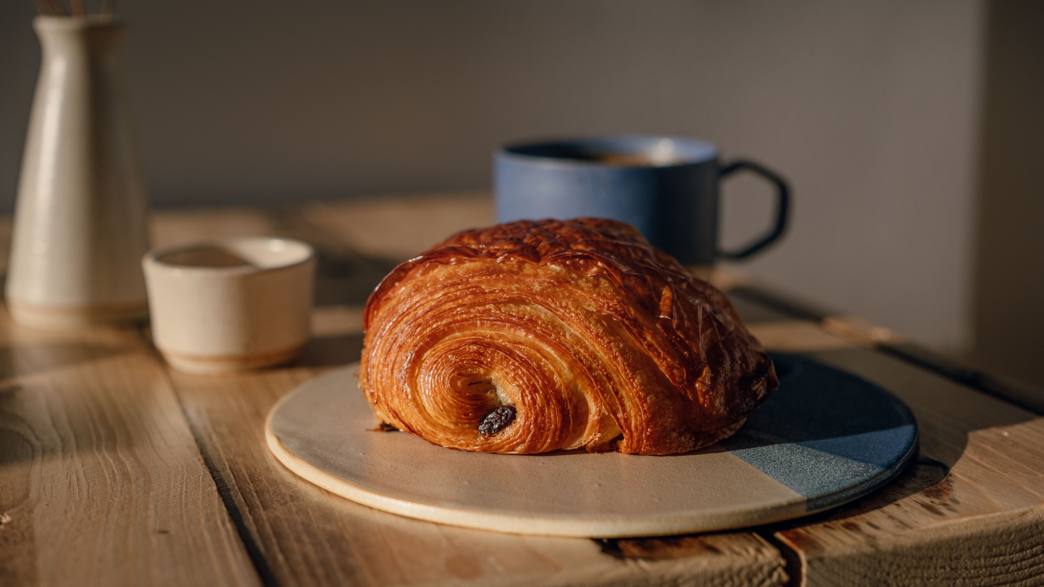 Pain au chocolat auf einem Teller mit Kaffee im Hintergrund im Sealevel Kaffebar.