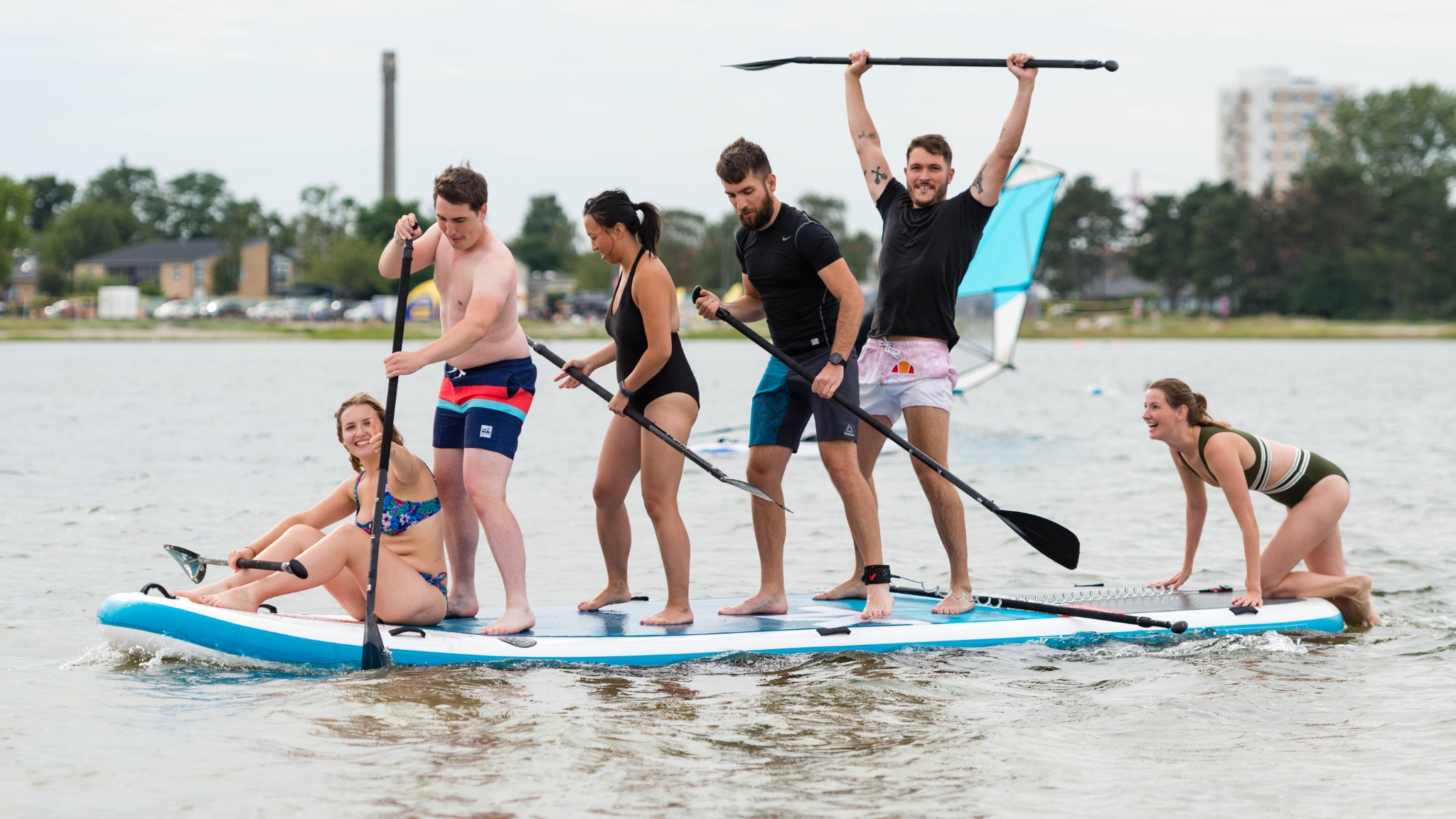 Group balancing on a large paddleboard in Frederikssund.