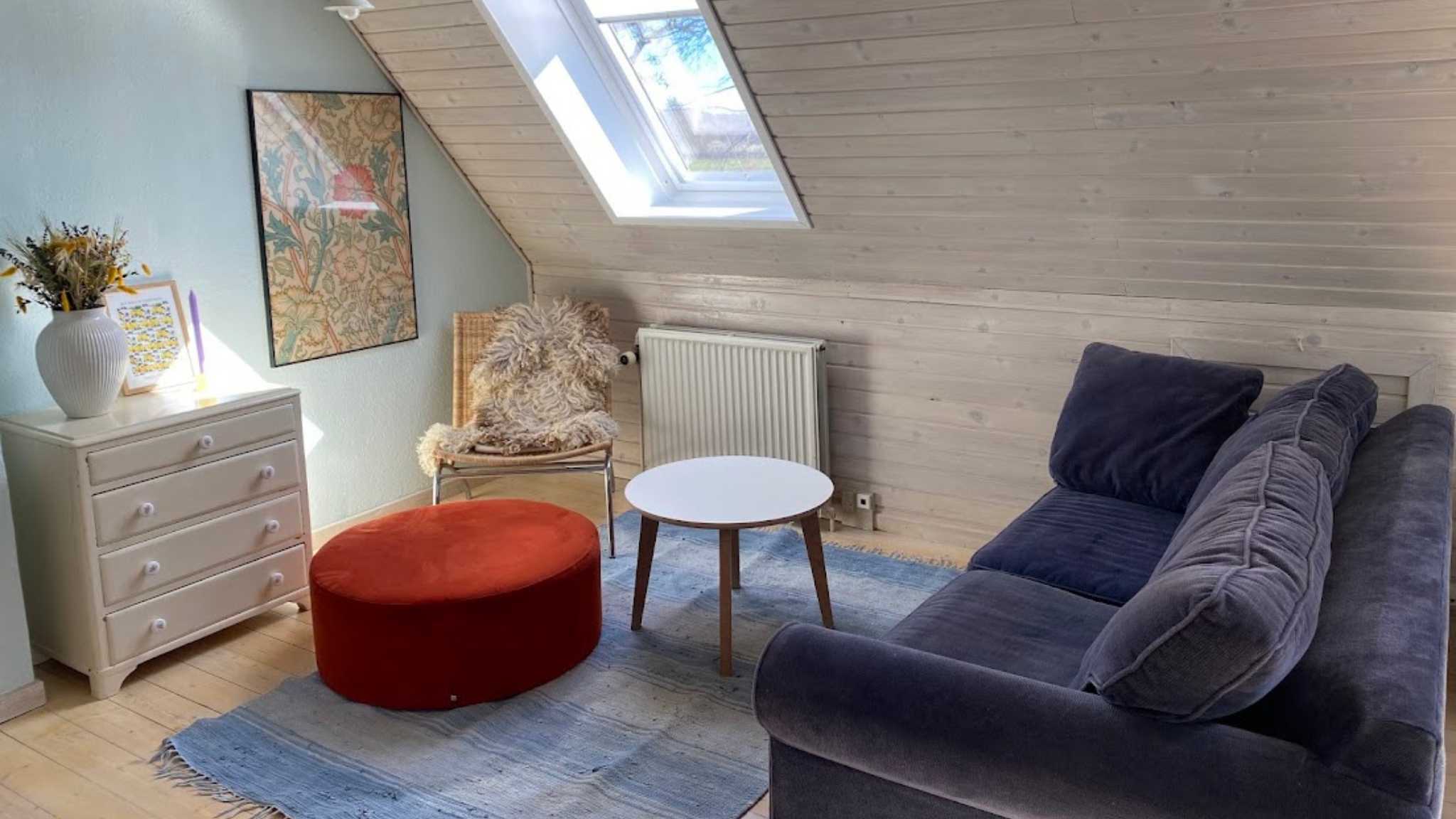 Hyggelig opholdsstue i gæstehus i Kattinge med sofa, ovenlysvindue og moderne indretning.