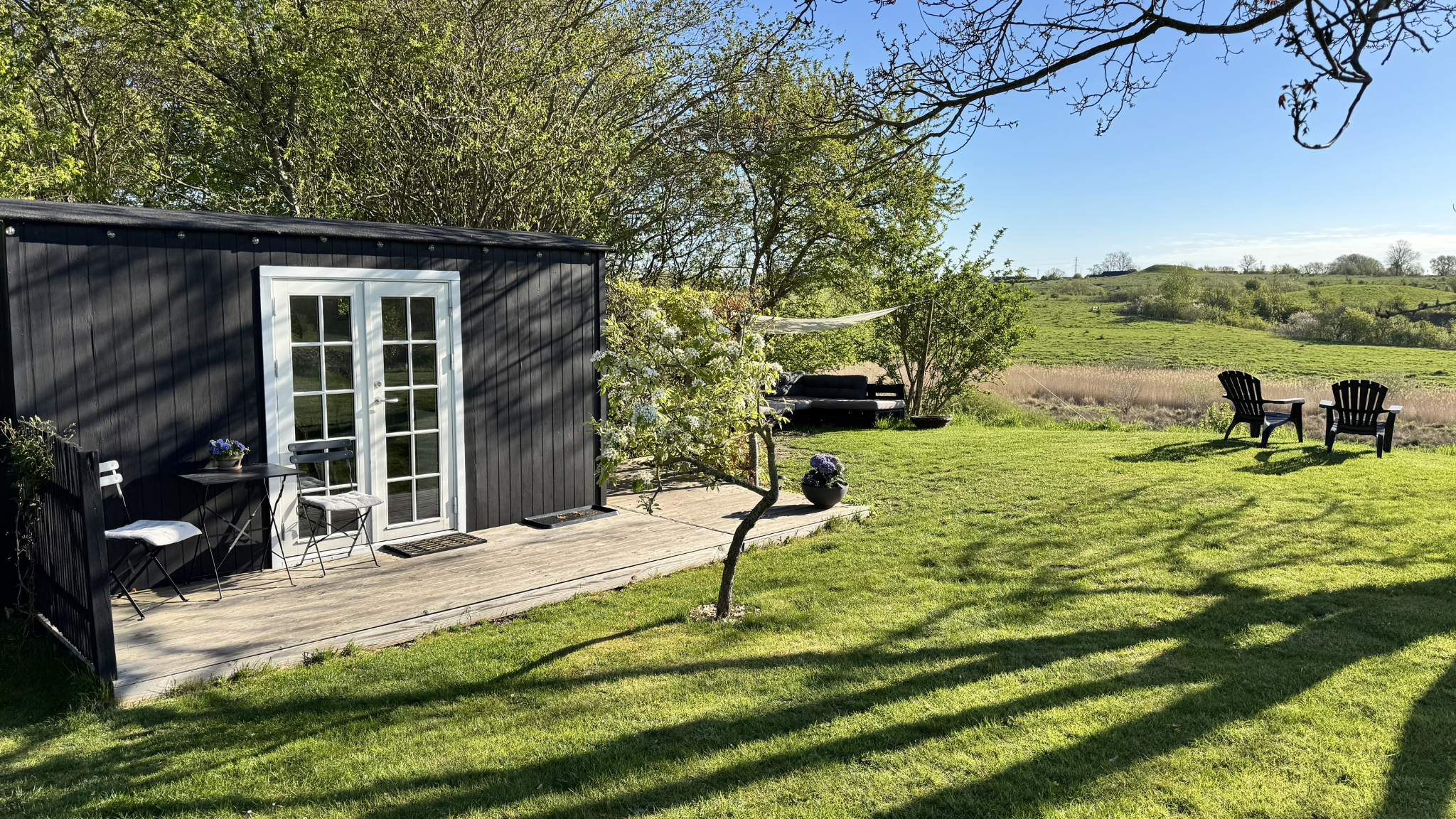 Tiny House i Gl. Lejre omgivet af grøn natur og udsigt over Nationalpark Skjoldungernes Land.