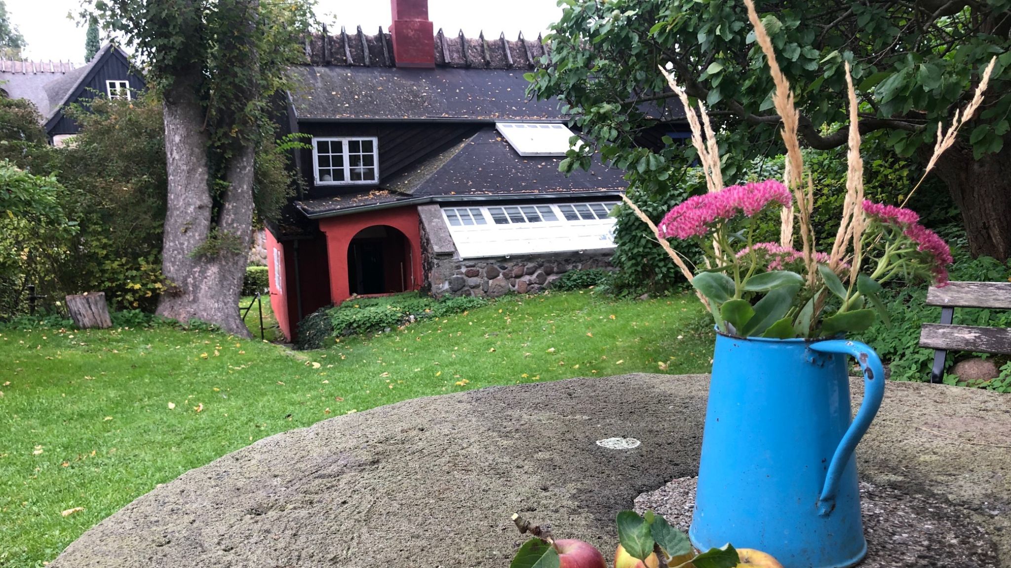 Garden at L. A. Ring’s studio with flowers in a blue jug and view of the house.