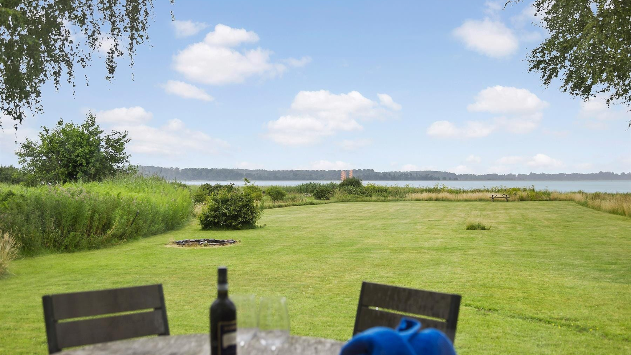 Græsplæne og fjordudsigt ved feriehus i Fjordlandet.