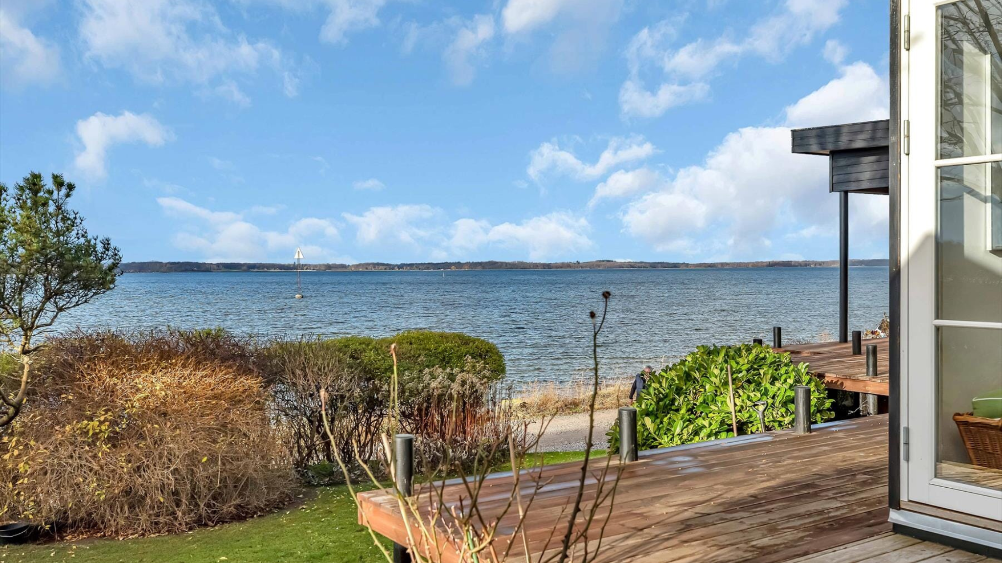 Sommerhus med terrasse og udsigt over fjorden.