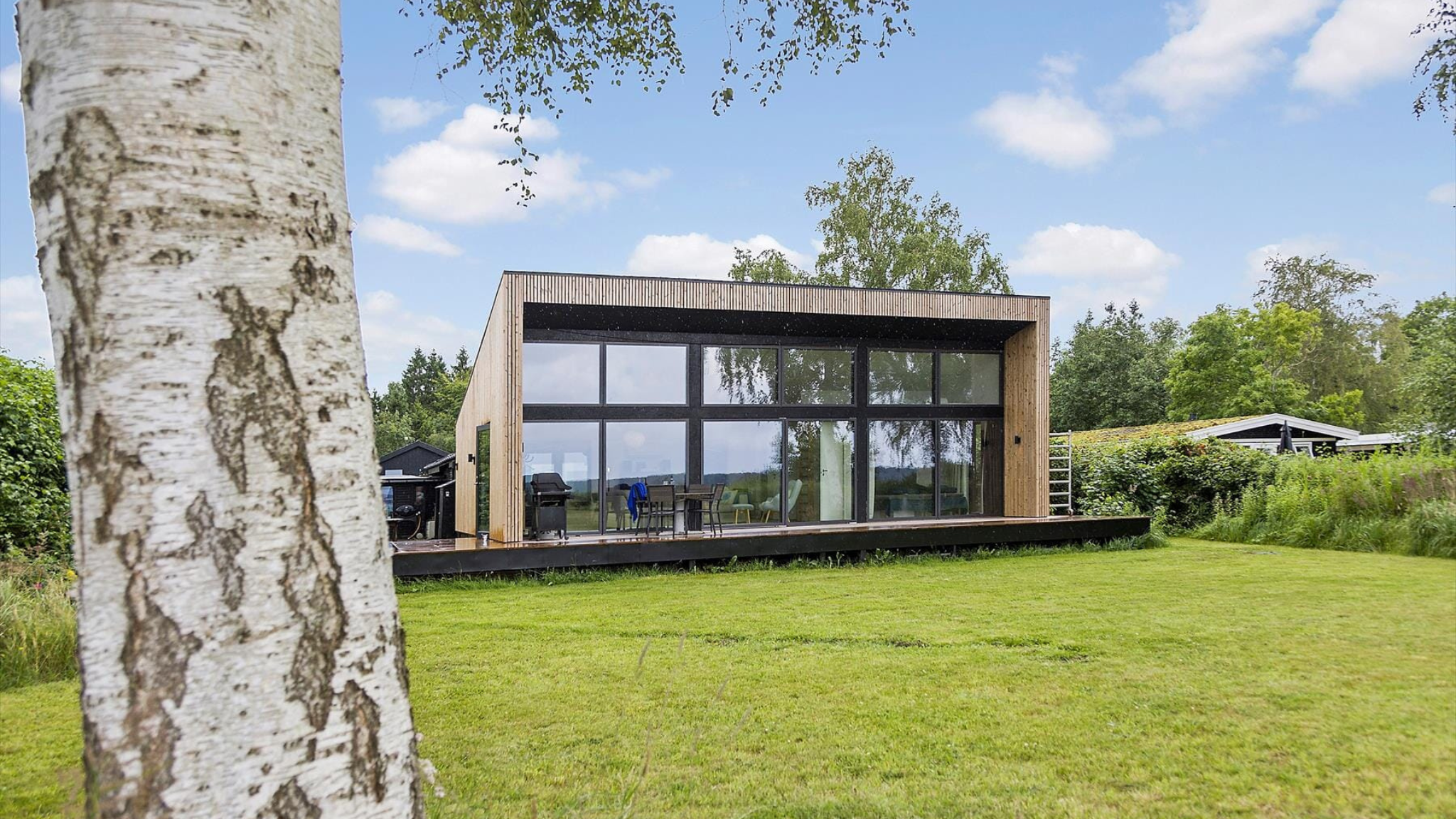 Moderne feriehus med store glaspartier og udsigt over naturen.