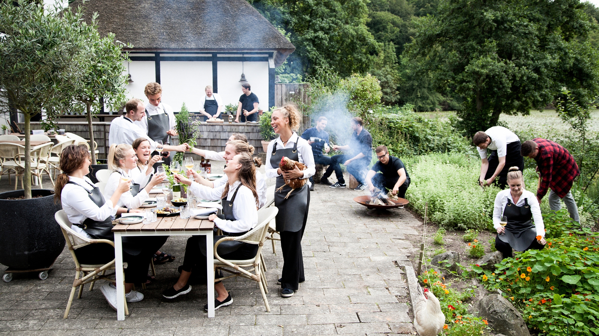 Outdoor dining at Herthadalen with guests and staff in scenic natural surroundings.
