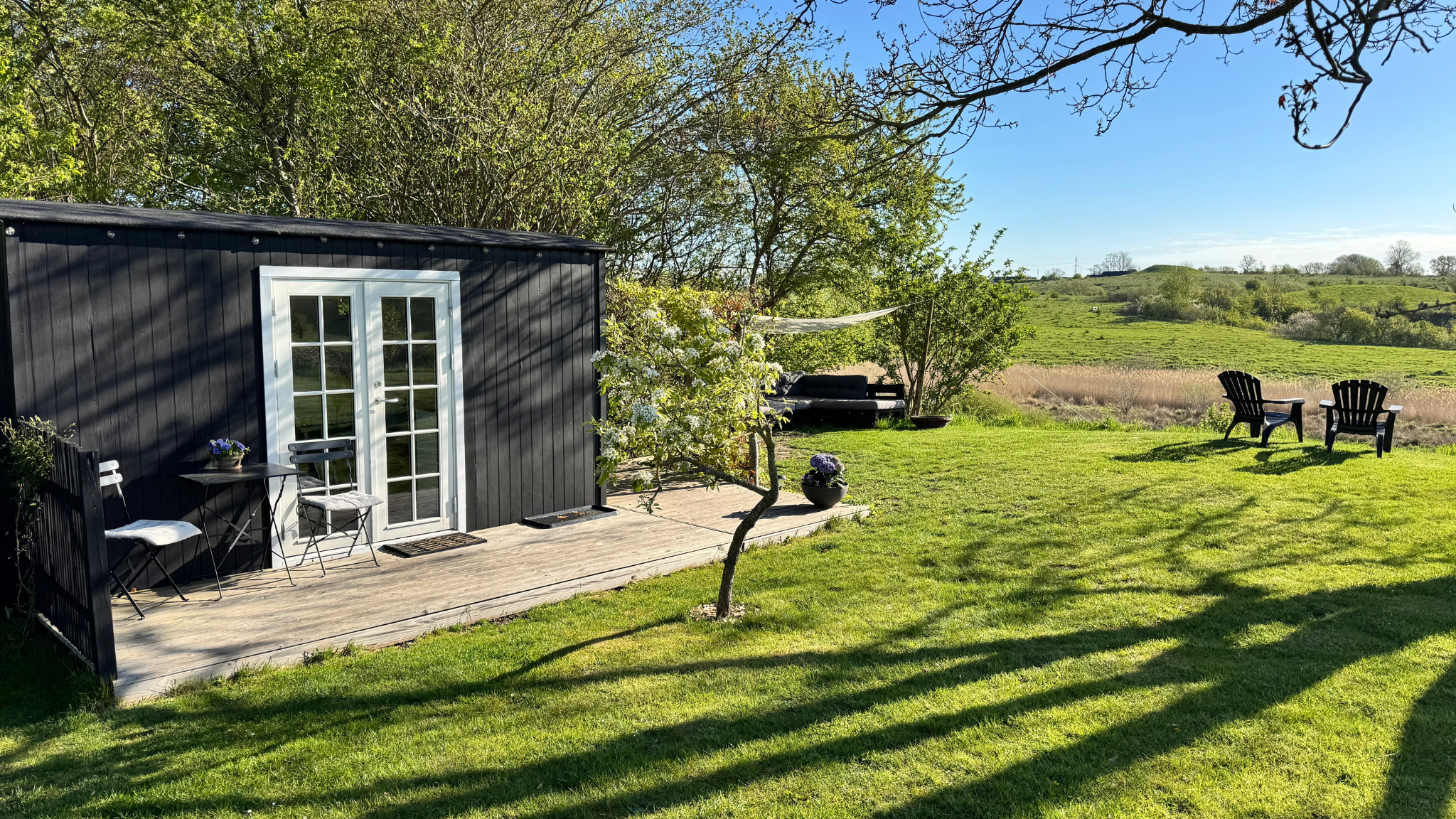 Tiny House Gl. Lejre with terrace overlooking the green countryside.