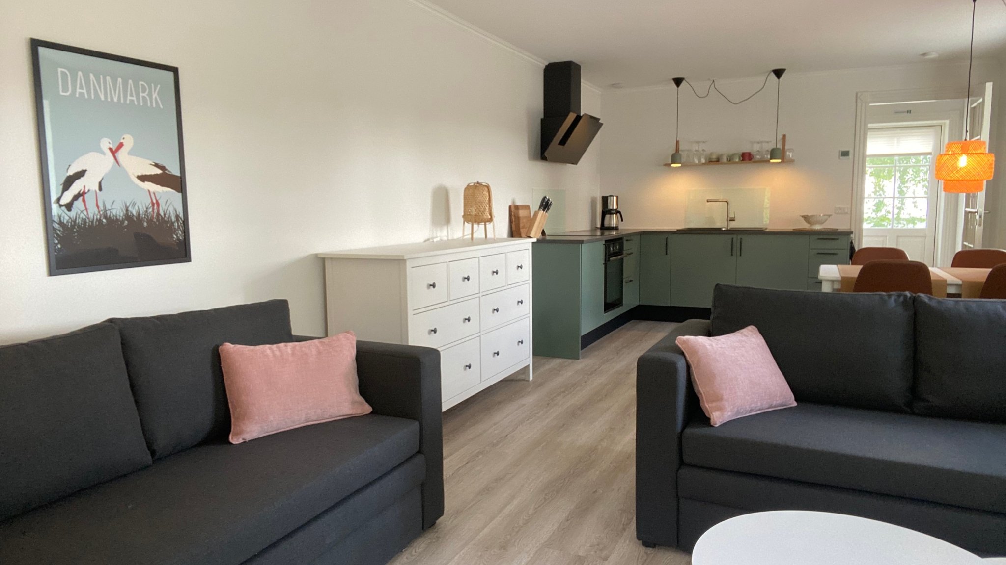 Helle Ferienwohnung bei LangeLinie Vin mit Sofas, offener Küche und Essbereich.