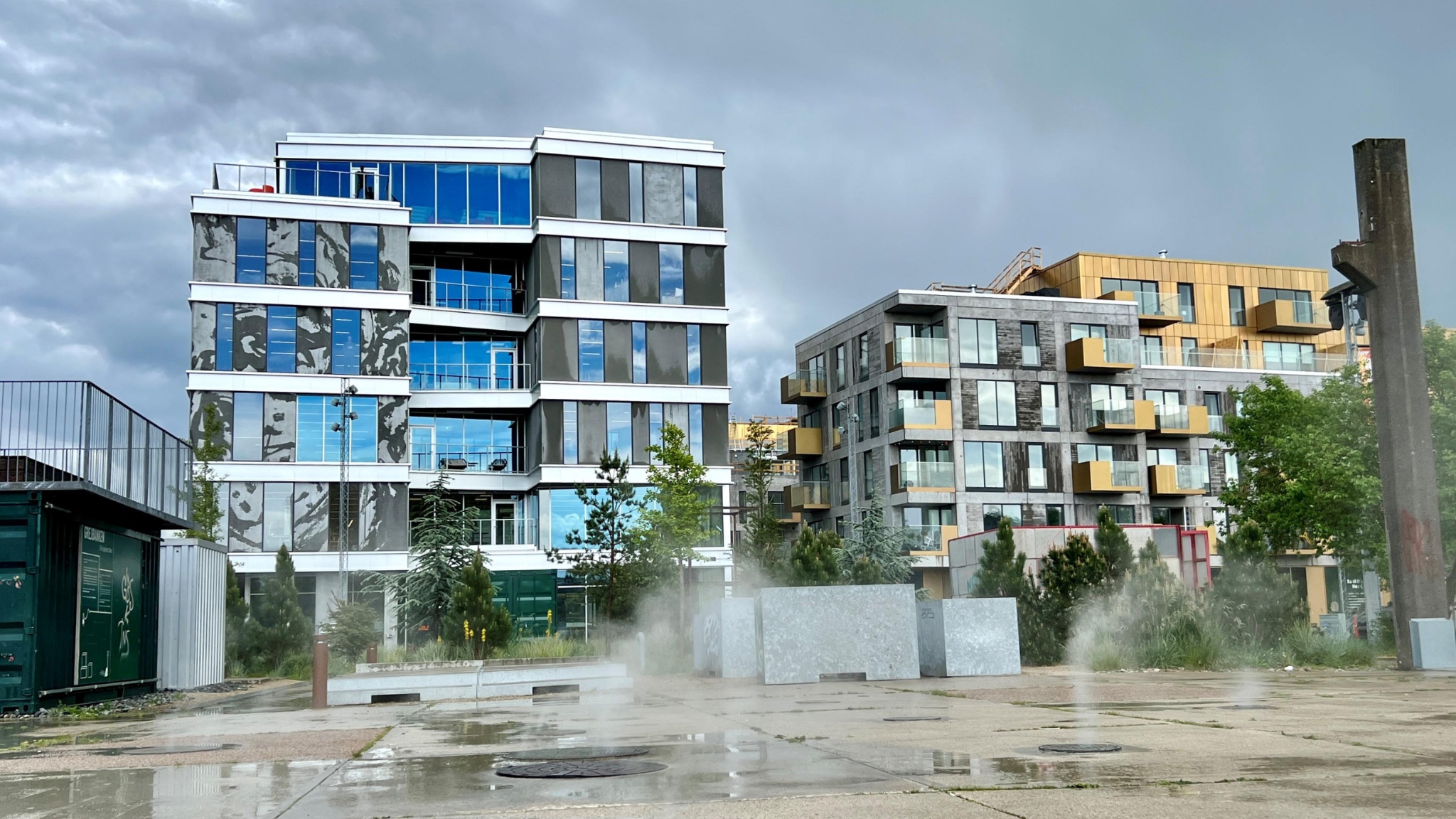 Modern homes beside an urban space with water at Musicon