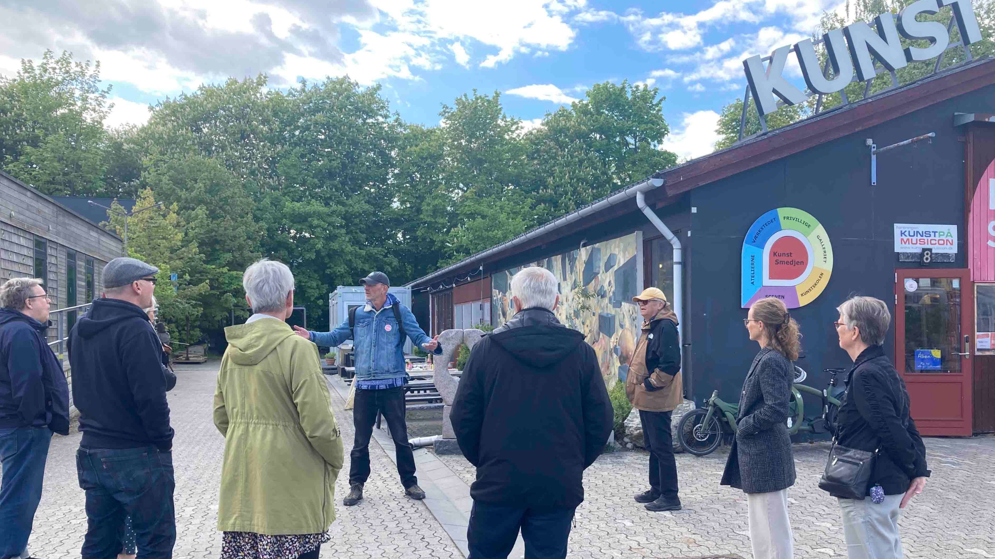 Group on a guided tour in front of a red building at Musicon in Roskilde