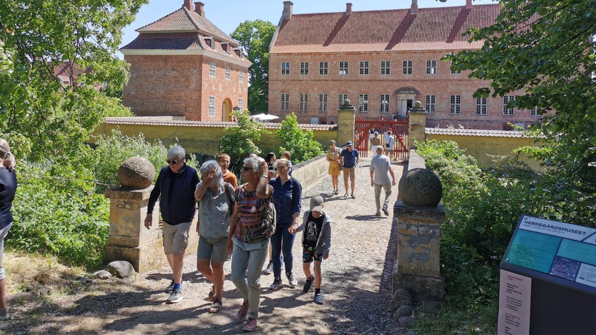 Visitors at Selsø Castle with the historic main building and castle gate in the background.