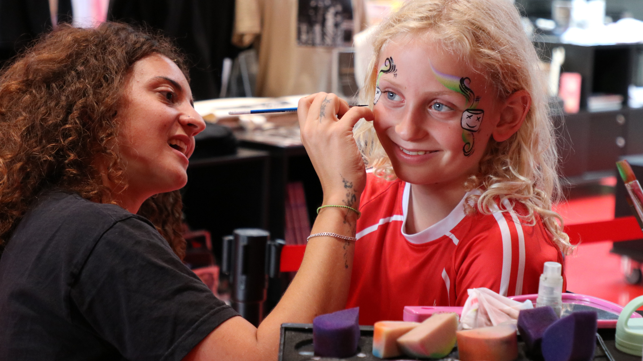 Child having colourful face painting during the autumn holiday at the rock museum.