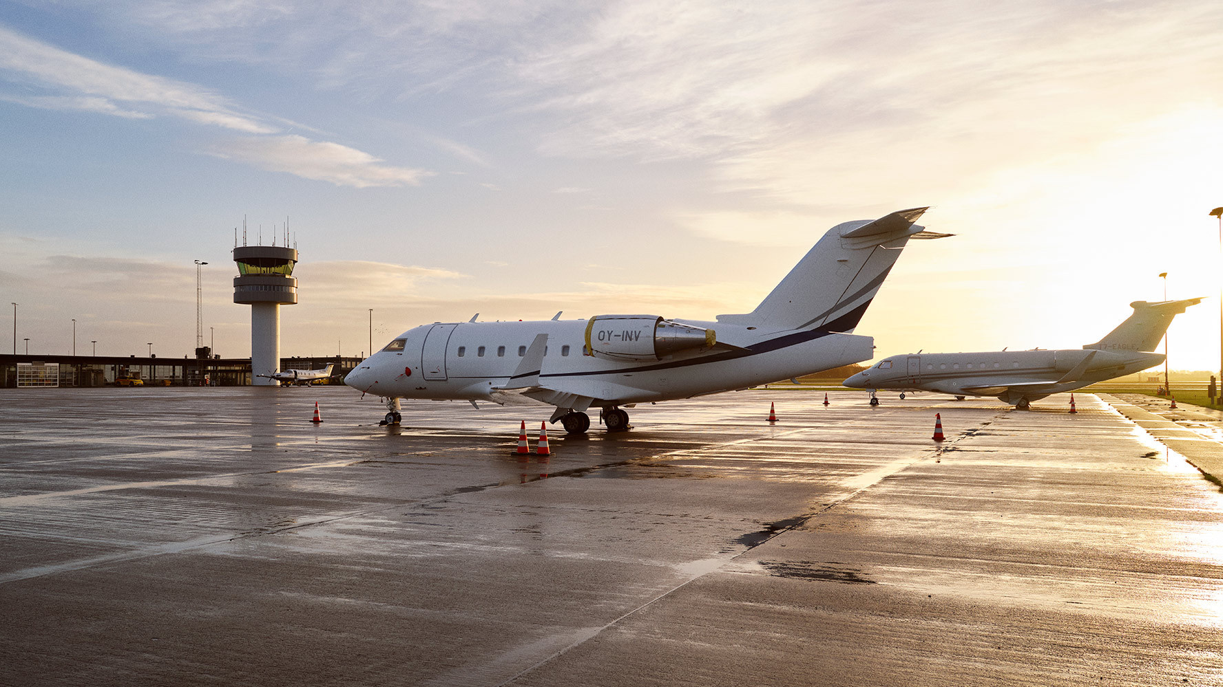 Business aircraft in front of the control tower at Roskilde Lufthavn in low sunlight