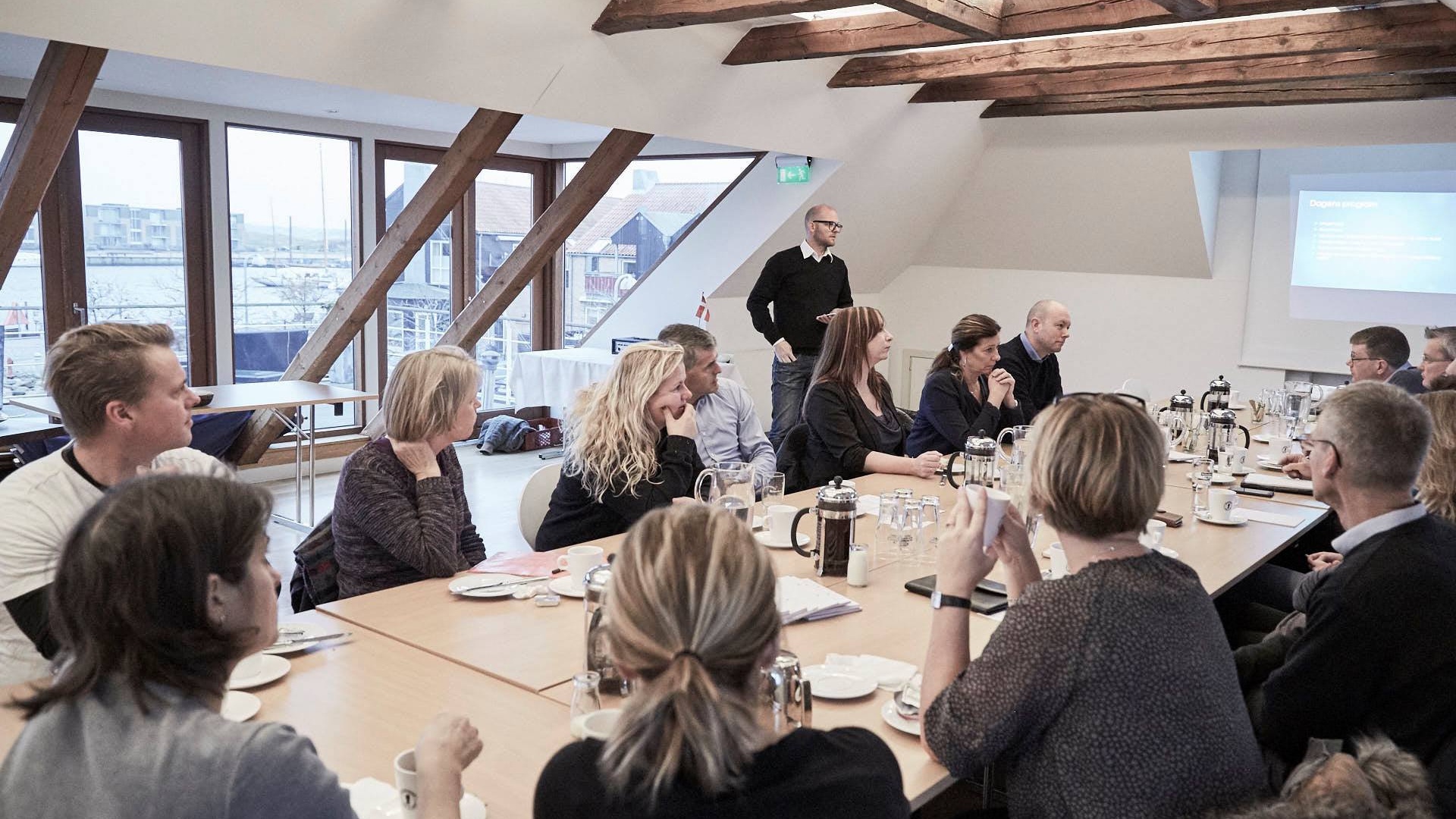 Meeting participants in a bright room at Restaurant Toldboden overlooking the harbour