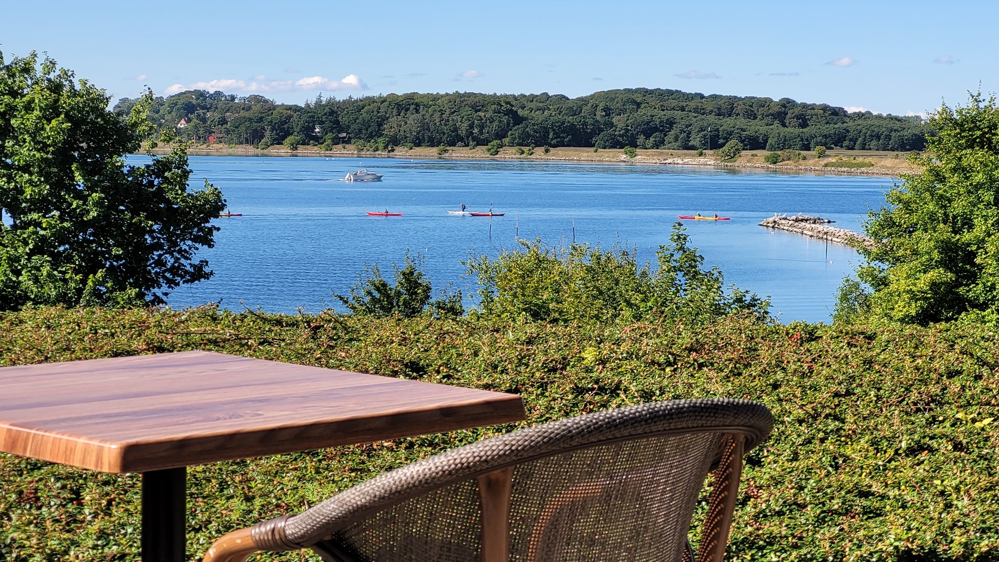 Table and chair on Restaurant Kalvø’s terrace overlooking Roskilde Fjord.