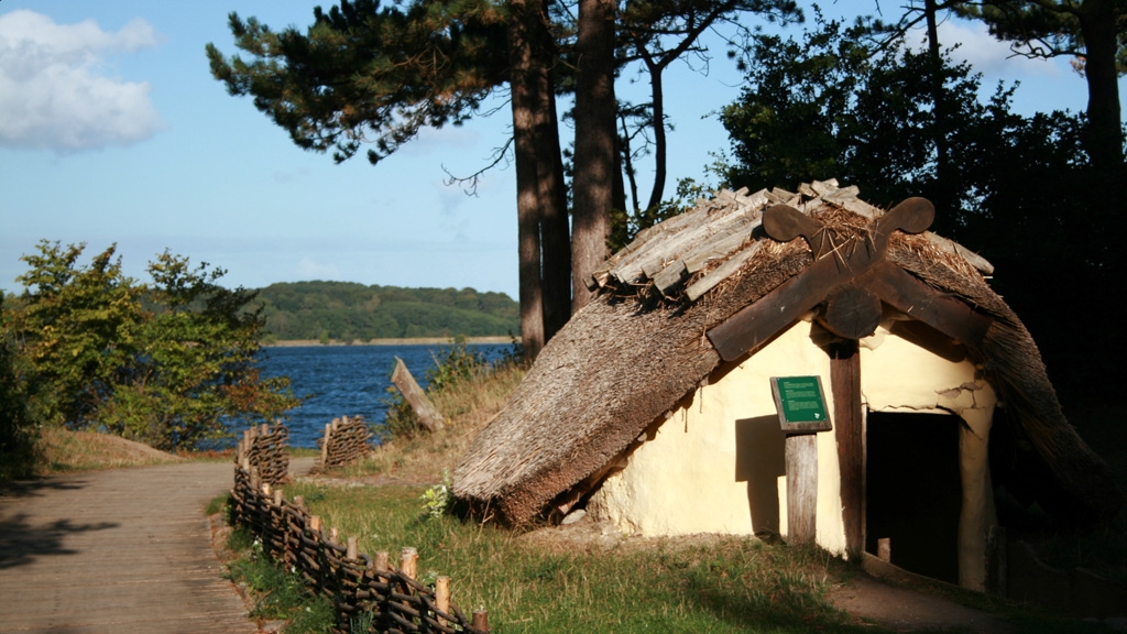 Grubehus og flethegn med fjorden bagved på Frederikssund Vikingeboplads.