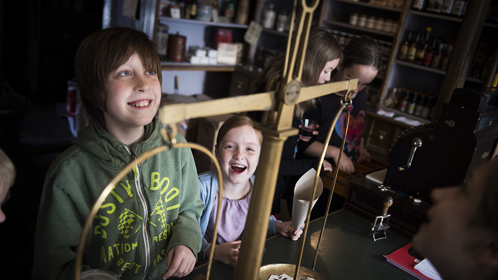 Children play shopkeeper and use the old-fashioned scales at Lützhøft’s Old Grocer’s Shop.