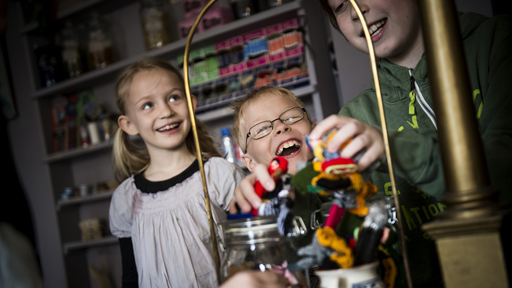 Children laugh and play shopkeeper with old-fashioned goods at Lützhøft’s Old Grocer’s Shop.
