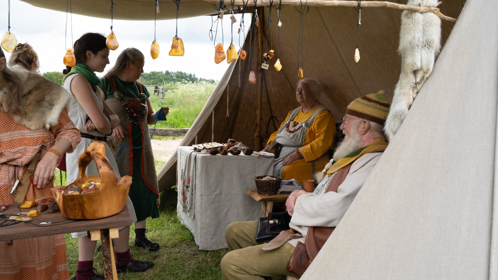 Mennesker i en markedsbod med rav til jernaldermarkedet i Vingsted
