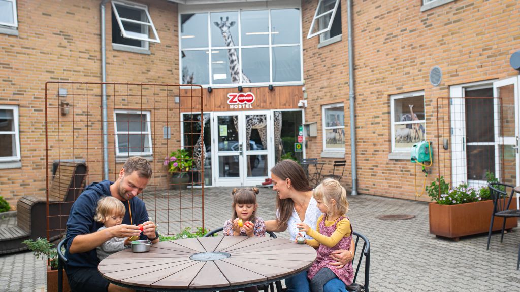 Gæster samlet ved havebordet på GIVSKUD ZOO HOSTEL