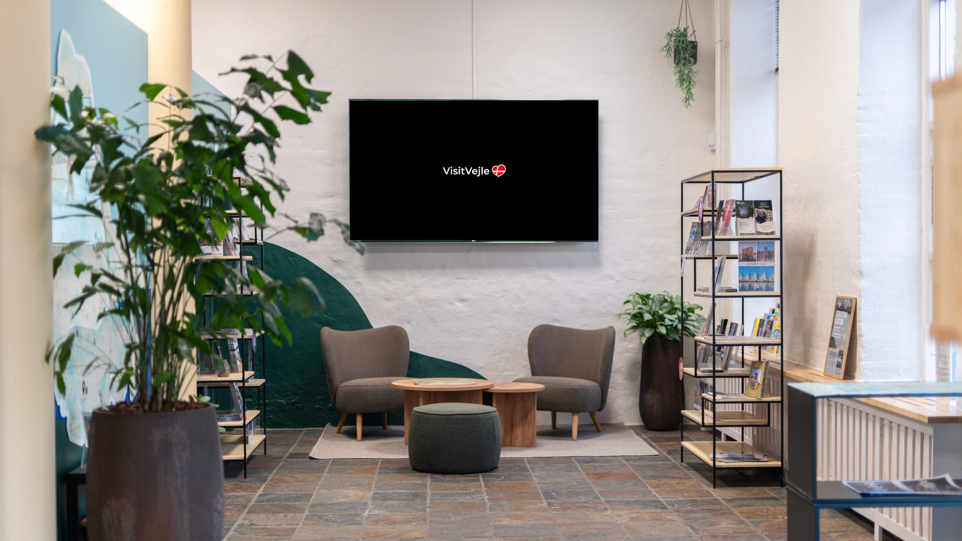 Sofaområde og grønne planter på turistkontoret hos VisitVejle