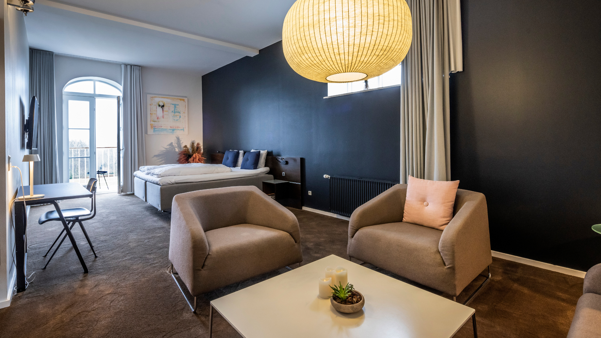 Værelse med dobbeltseng og lænestole på Comwell Kellers Park hotel ved Vejle Fjord