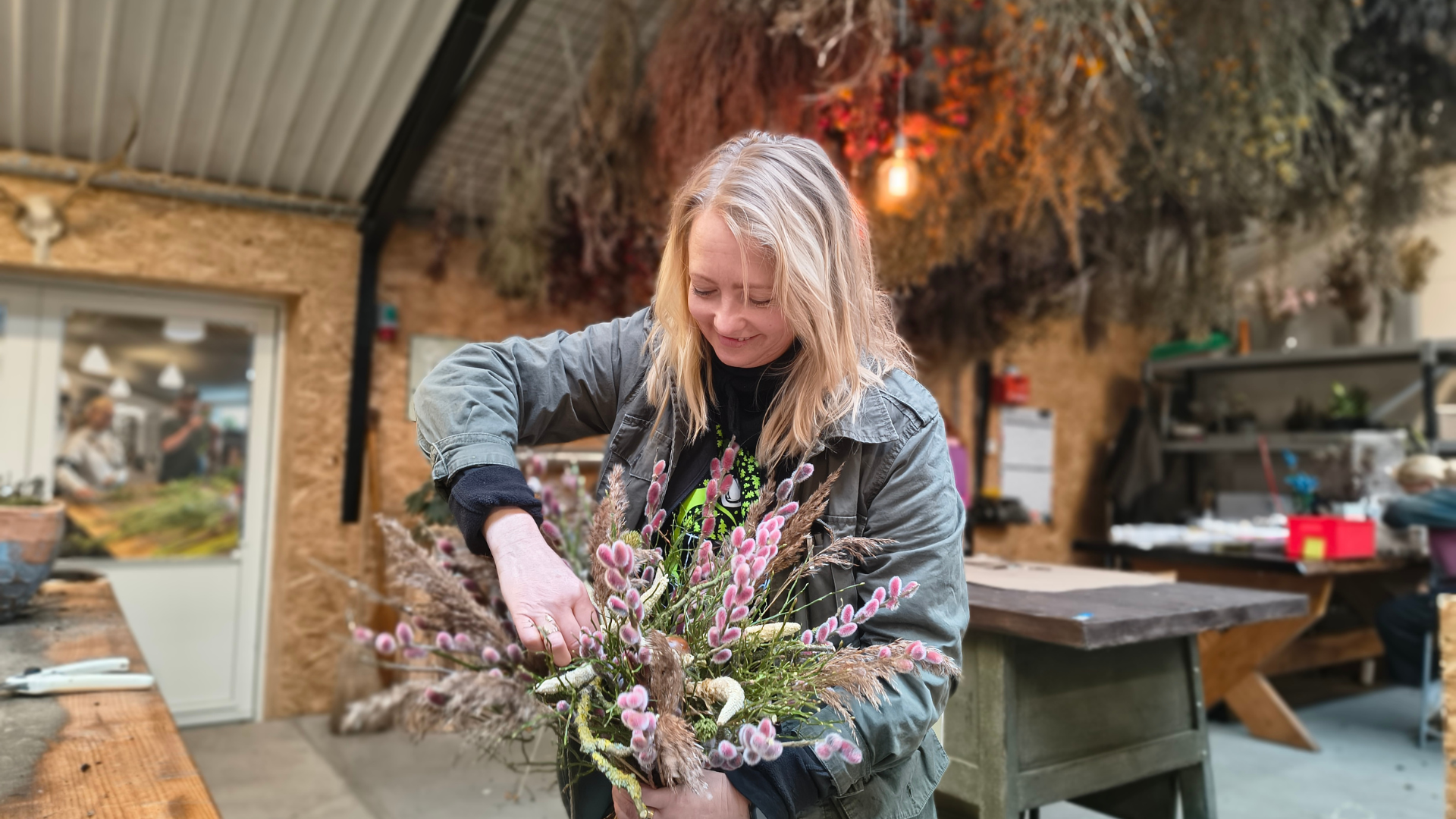 Woman arranging flowers at Tinnetgård near Vejle for an event