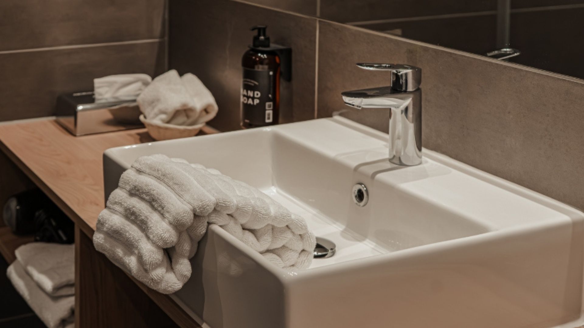 Badeværelse med håndvask og håndklæder