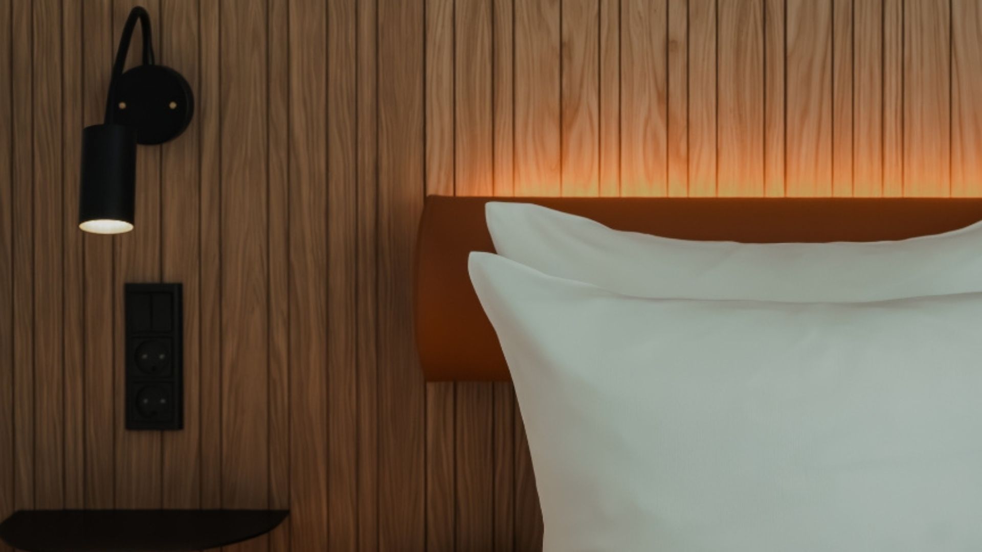 Detalje af seng og sengegavl med stemningsbelysning hos VILLAVEJLE