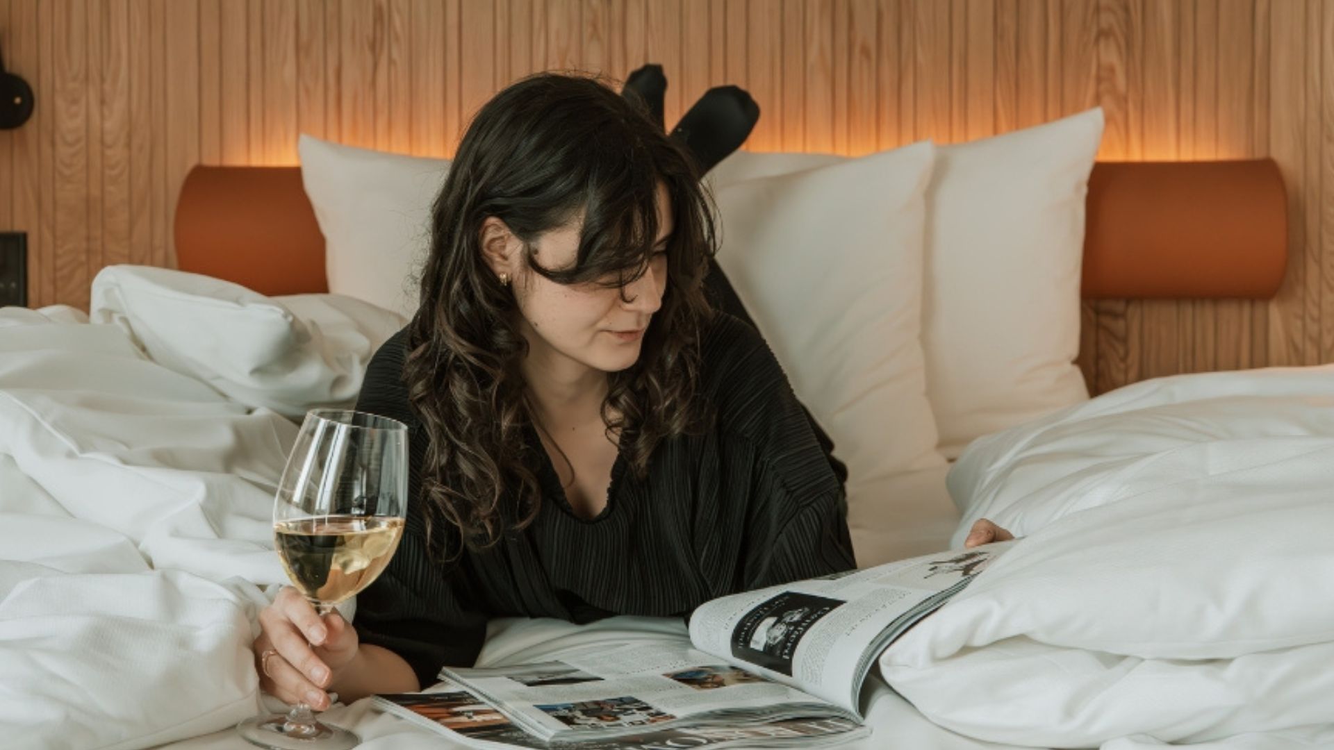 Gæst nyder en afslappende stund i sengen med yndlingsmagasin