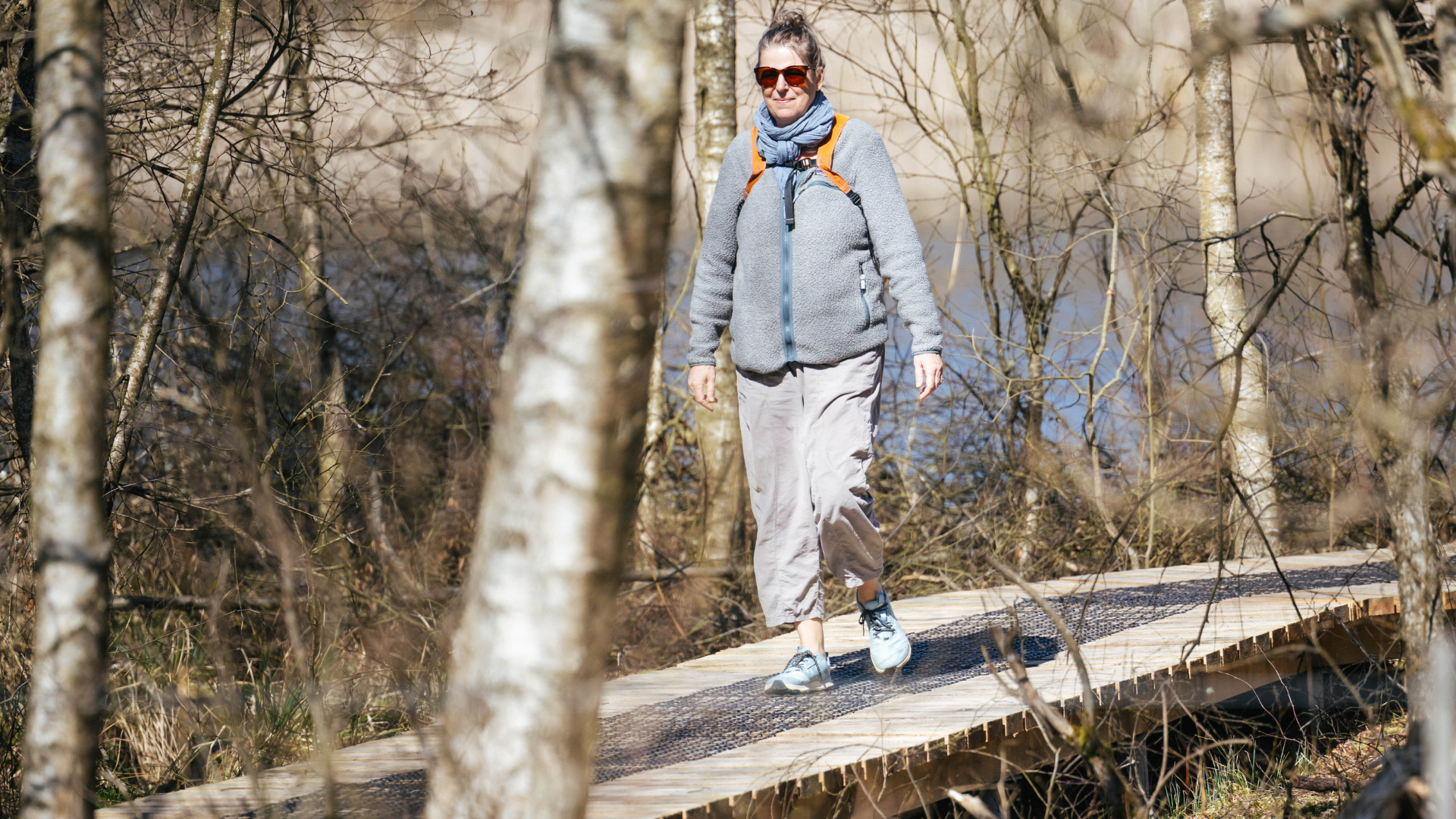 Woman walking along a footbridge on the Gudenå Trail in Vejle Municipality