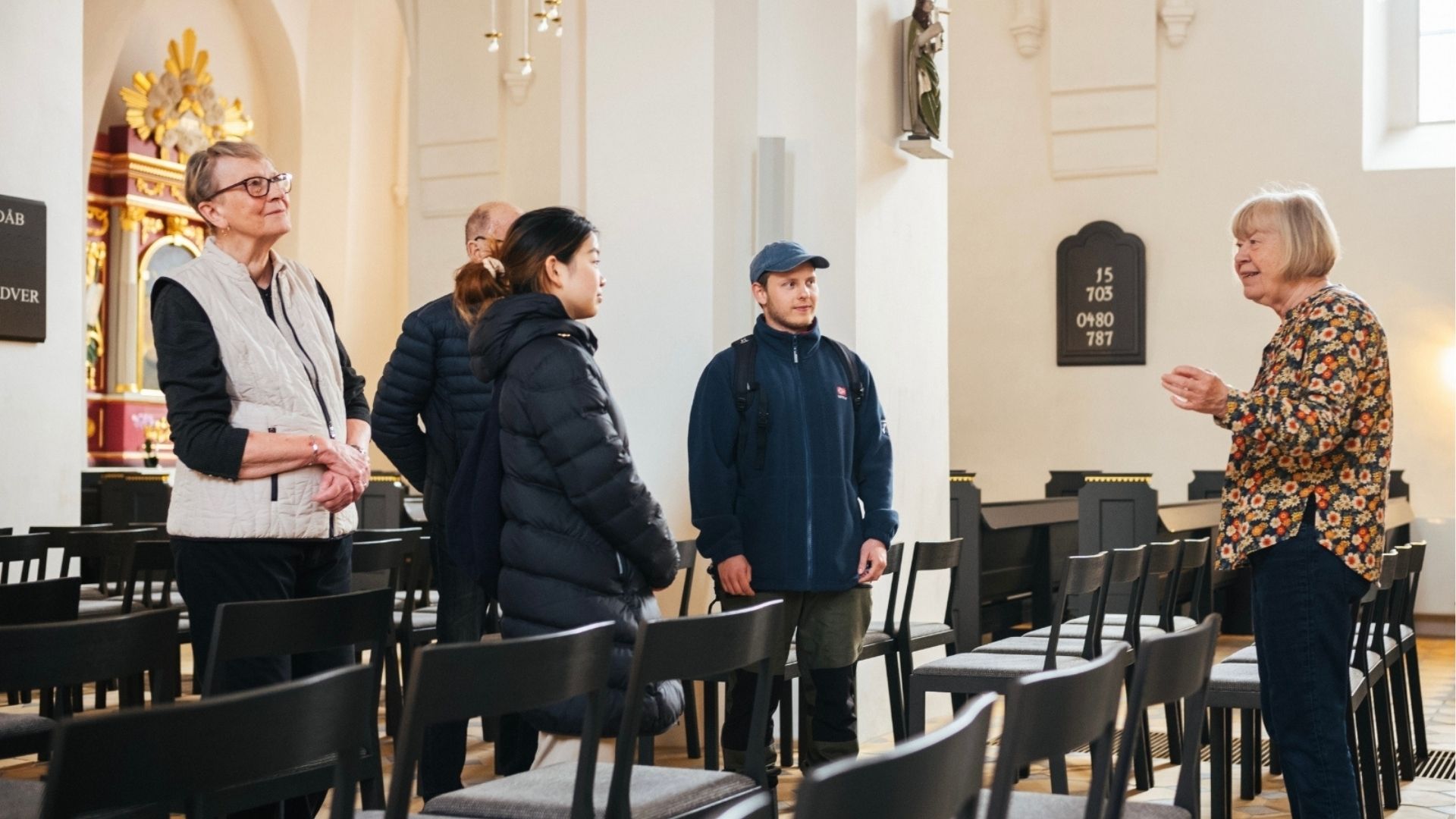 People are taking part in a guided tour of Sankt Nicolai Church in Vejle.